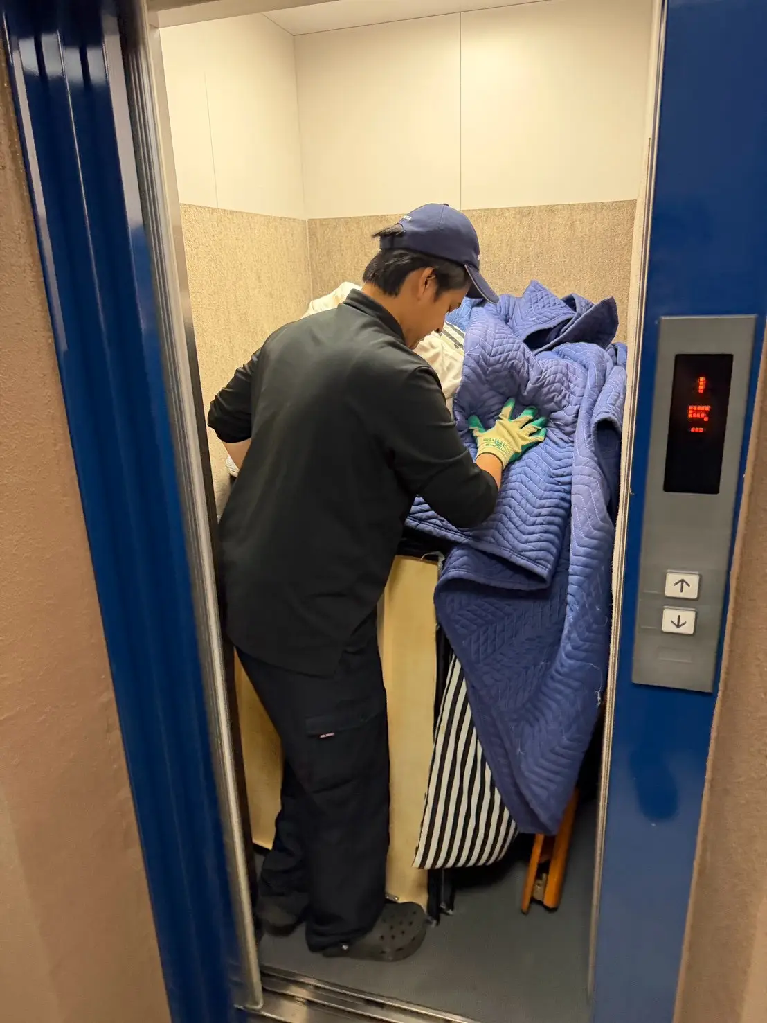 養生した家具をエレベーターで運ぶ様子