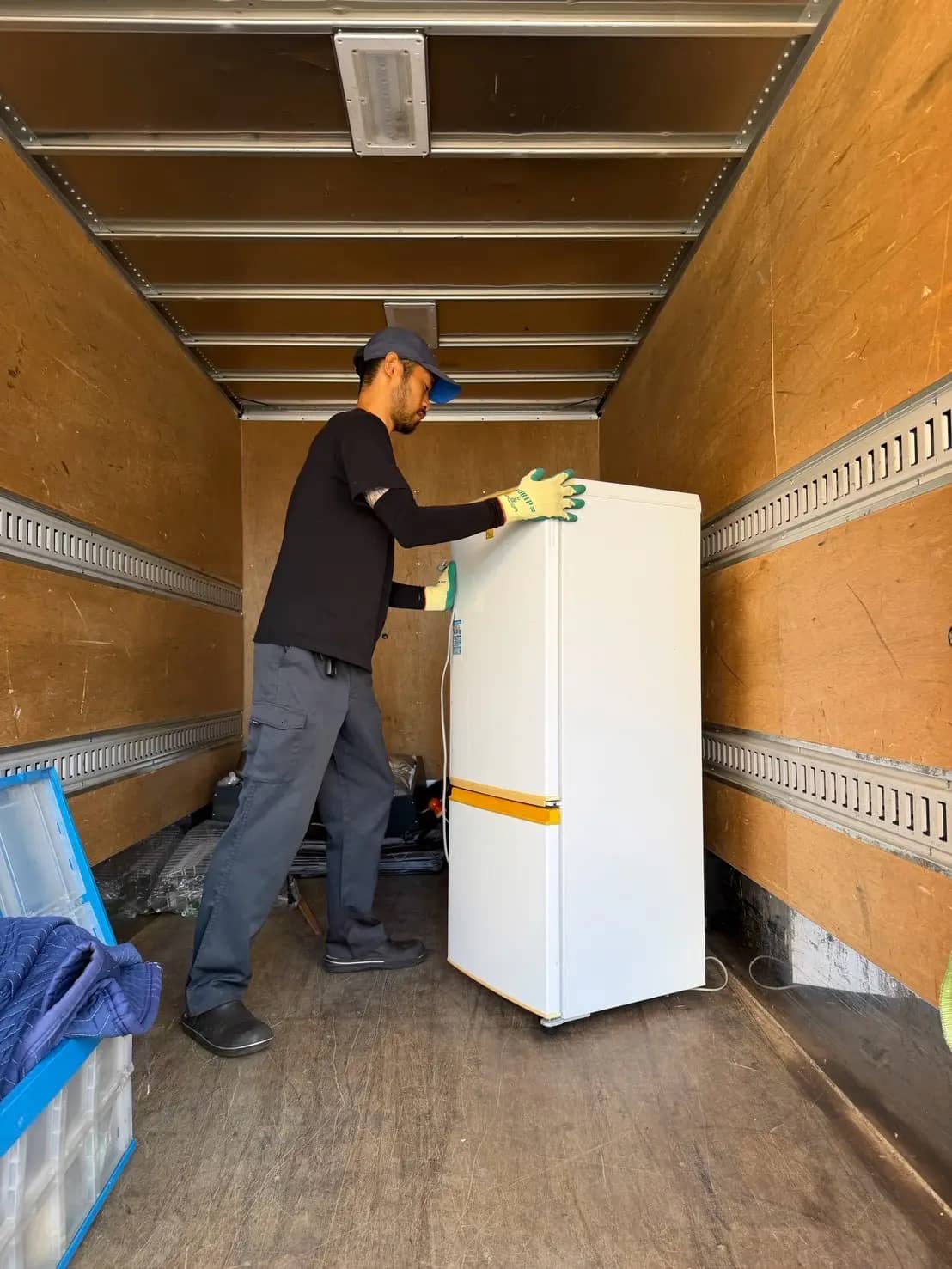 トラックの荷台に冷蔵庫を積み込む様子